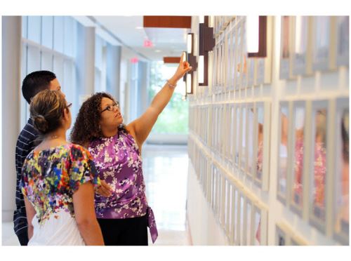 Woman Pointing at Wall of Heroes